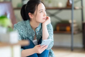 携帯で調べ物をする女性